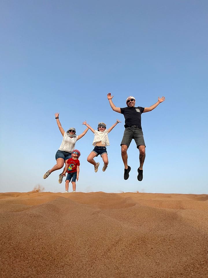 Une famille qui saute dans le désert de Dubaï