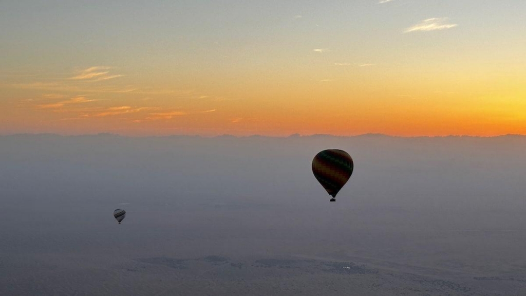 Hot air balloon and sunrise over the Dubai desert